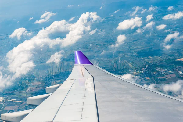 Wing of the aircraft view from the window, the fields and the ci — Stock Photo, Image