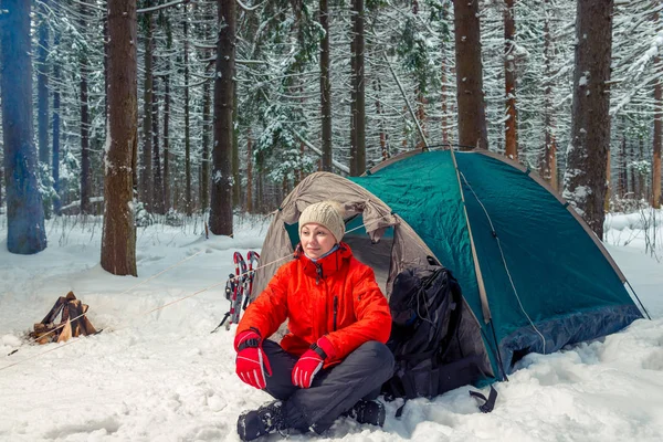 Relaxed tourist woman sitting near a tent in a winter forest — Stock Photo, Image