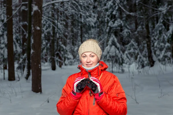 Hermosa turista con prismáticos en un bosque de invierno —  Fotos de Stock