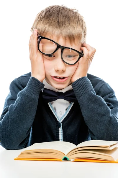 Upset schoolboy with a book on a white background — Stock Photo, Image
