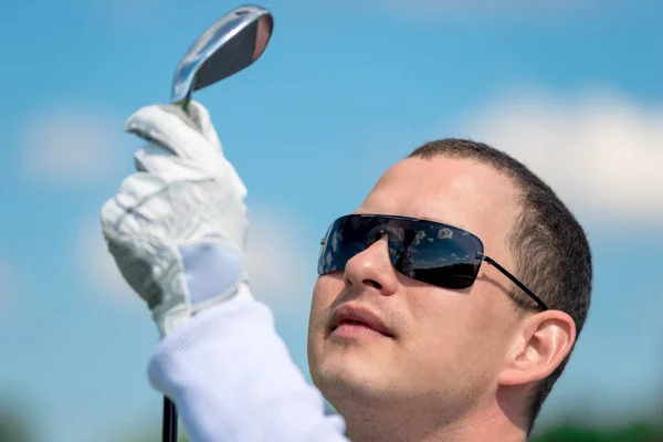 Retrato de um golfista olhando para o seu clube de golfe de perto — Fotografia de Stock