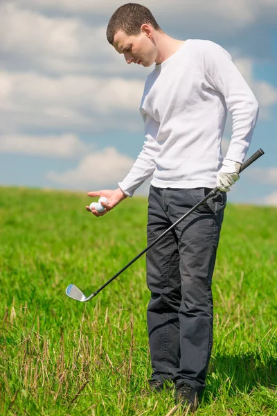 Golfaren i full längd på fältet med bollar och en golfklubb — Stockfoto