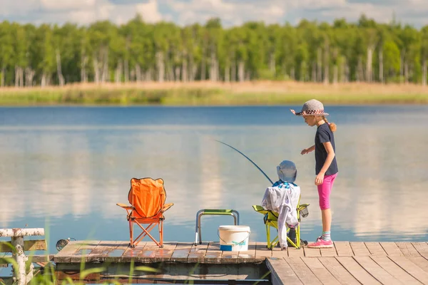 Malý rybáři dívka a chlapec při rybaření na dřevěném molu — Stock fotografie