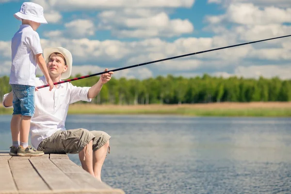 Рибалки батько і син на пірсі риби в озері — стокове фото