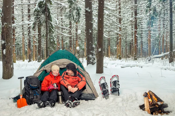 Man and woman active tourists, campground in the winter forest — Stock Photo, Image