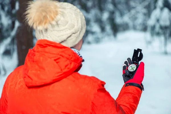 La ragazza è guidata nella foresta invernale dalla bussola, la vista — Foto Stock