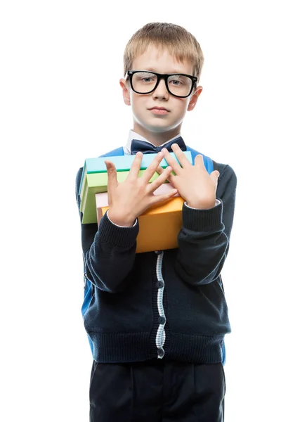 Garçon 8 ans avec une pile de manuels sur un fond blanc i — Photo