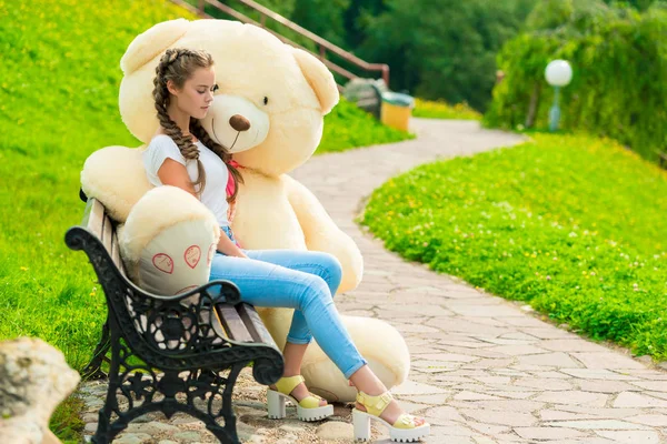 Bir parkta bir bankta onu büyük oyuncak ayı ile 20 yaşındaki kız — Stok fotoğraf