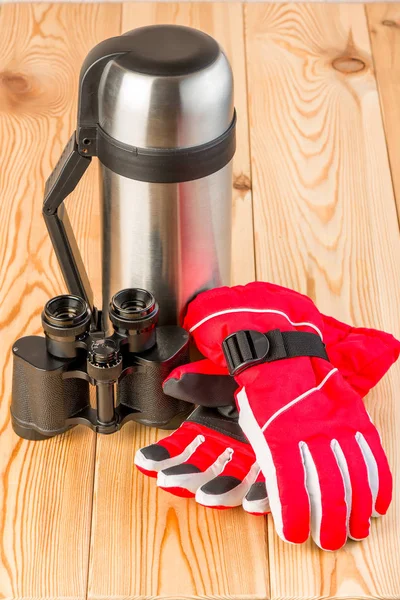 Warme handschoenen, verrekijkers en een thermoskan met thee klaar voor een moeilijke — Stockfoto
