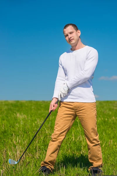 Golfista con un club de golf en un campo verde en un día soleado —  Fotos de Stock