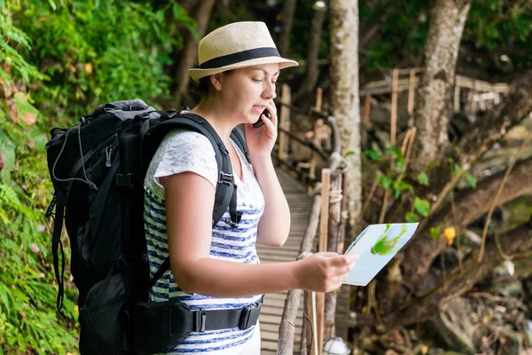 Verloren toerist met een rugzak en kaart oproepen voor hulp per telefoon — Stockfoto