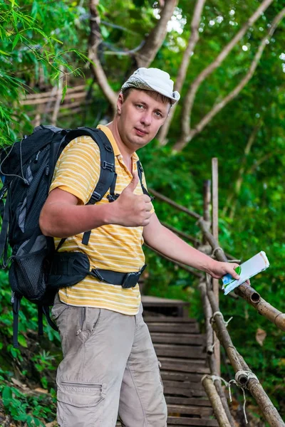 Um turista satisfeito com uma mochila e mapa na viagem — Fotografia de Stock