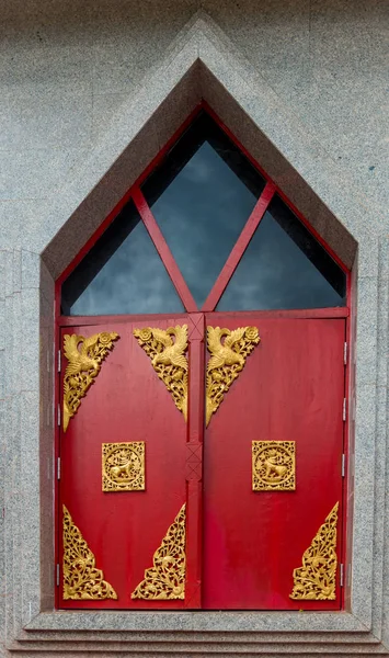 Red window shutters decorated with gold ornaments on a temple in — Stock Photo, Image