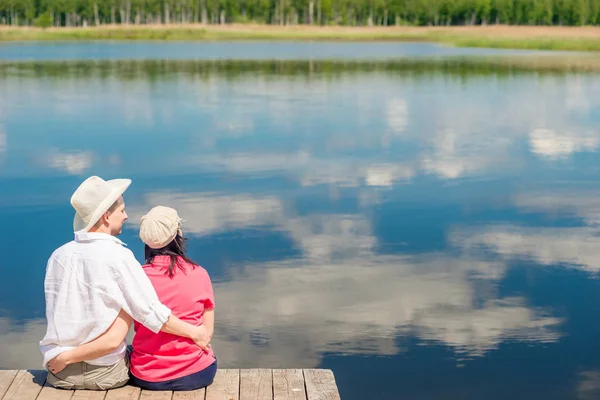 Happy couple hugging, view from behind in the background of a be — Stock Photo, Image