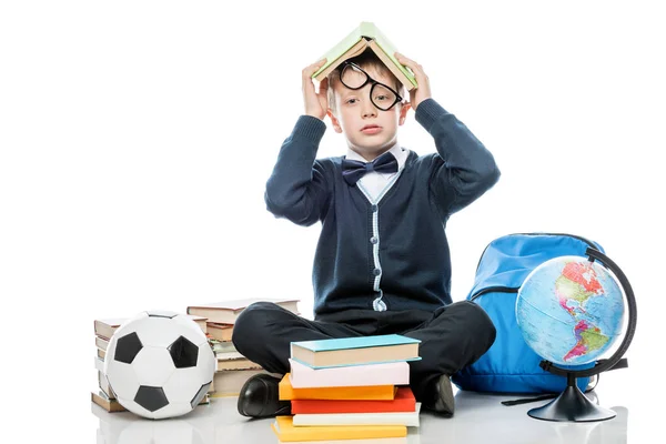 Tired schoolboy with book on his head posing against white backg — Stock Photo, Image