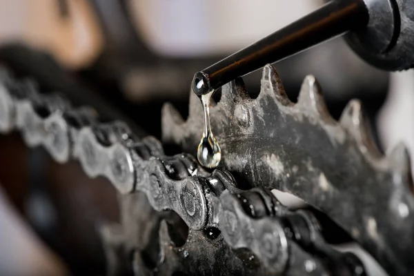 Una gota de aceite y una cadena de bicicletas de montaña de cerca —  Fotos de Stock