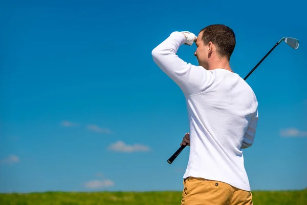Golfista mirando lejos trayectoria de volar su pelota en el ai abierto —  Fotos de Stock