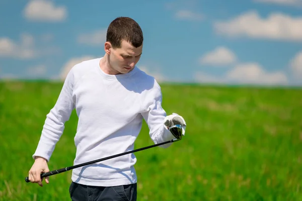 Retrato de um golfista inspecionando seu clube de golfe antes de jogar em — Fotografia de Stock