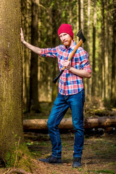 Retrato vertical de un leñador barbudo de cuerpo entero con un hacha —  Fotos de Stock