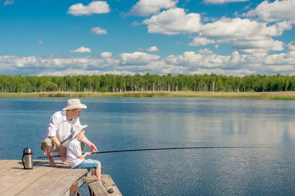 Family fishing on a beautiful lake with fishing rods — Stock Photo, Image