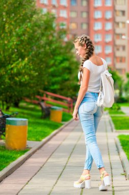 şık genç kız bir sırt çantası ile şehir etrafta dolaşıyor r