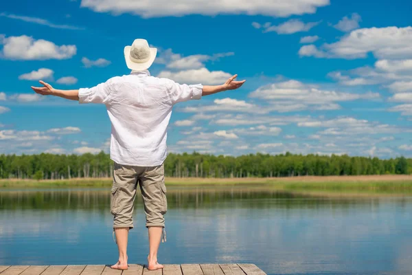 Un jeune homme en chemise blanche et chapeau profitant de la belle natu — Photo