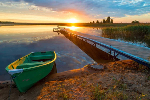 Prachtige landelijke landschap - een houten pier en een boot in de stralen — Stockfoto