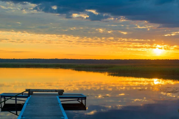 Oranje landschapsmening van een houten pier in de buurt van een schilderachtige kalm l — Stockfoto