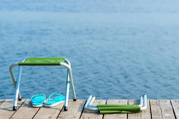 Two chairs and slates on a wooden pier near the water, no people — Stock Photo, Image