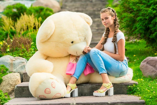 Hermosa chica de 20 años con un gran osito de peluche en el parque en —  Fotos de Stock