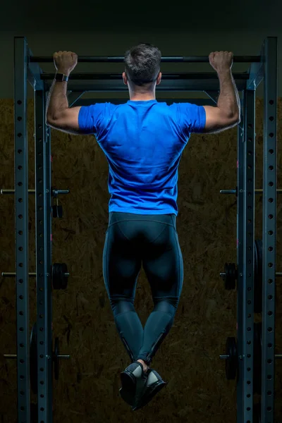 Forte atleta tira sul bar in palestra vista dalla parte posteriore — Foto Stock