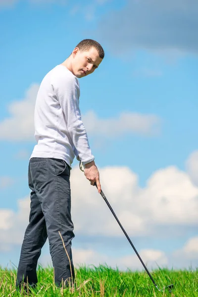 Un joven golfista exitoso se prepara para golpear la pelota con una c de golf — Foto de Stock