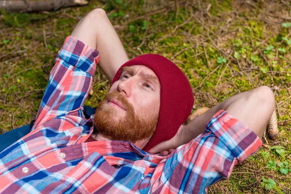 Porträt eines Hipsters mit Bart und rotem Hut, der in der — Stockfoto