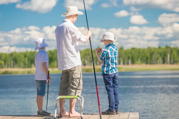 Een man's hobby - een vader met zijn zonen inzake de visserij in goede weathe — Stockfoto