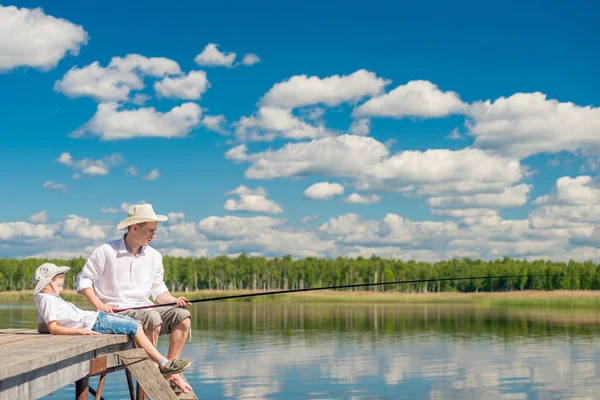 Relaxado menino com seu pai em uma viagem de pesca em um belo lago — Fotografia de Stock