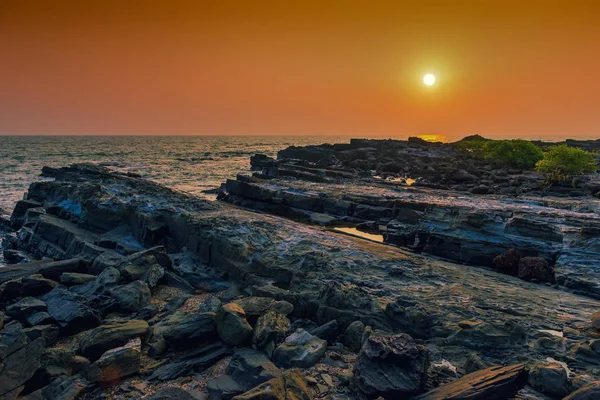 Felsige menschenleere und ruhige See bei Sonnenuntergang. getönt. — Stockfoto