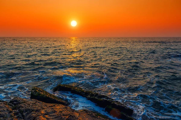 Meereswellen und orangefarbener Himmel bei Sonnenuntergang. getönt. — Stockfoto