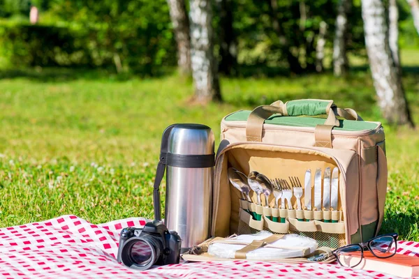 A thermos bottle with utensils, a thermos with tea and a camera — Stock Photo, Image