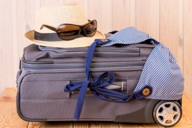 Hasır şapka, bikini ve güneş gözlüğü kapalı gri bavula yalan