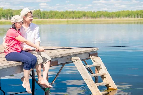 Šťastný pár na molu s bosýma nohama, chytání ryb na krasavice — Stock fotografie