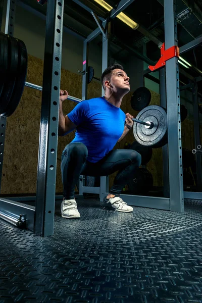 Atleta con bilanciere in palestra, foto scura — Foto Stock