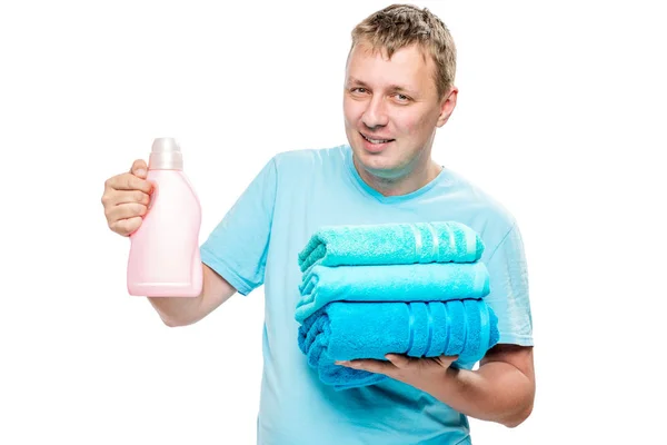 Портрет счастливого мужа с чистыми полотенцами и гелем для стирки — стоковое фото