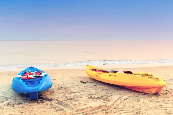 Twee kajaks op het strand in de vroege ochtend. Getint. — Stockfoto