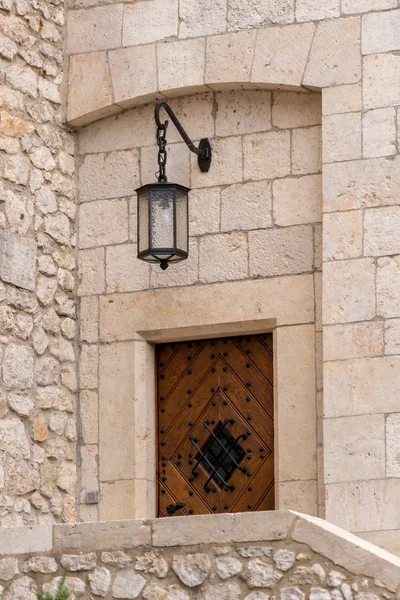 Kamenné zdi středověkých budovy s dřevěnými dveřmi a lante — Stock fotografie