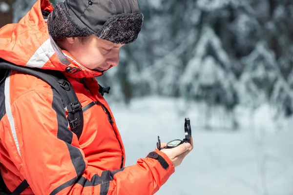 Um turista perdido olhando para uma bússola, atirando em uma floresta de inverno — Fotografia de Stock