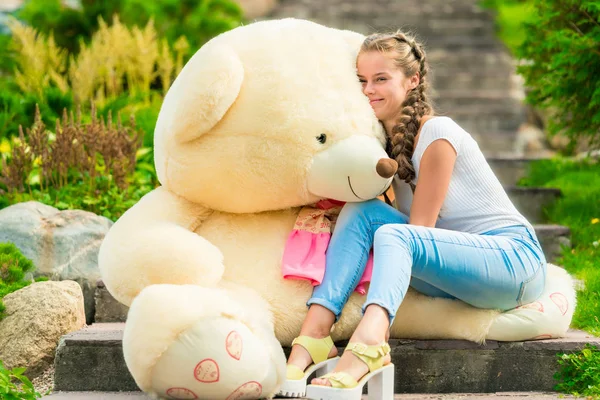 20 anos de idade menina feliz com um grande urso de pelúcia no parque no — Fotografia de Stock