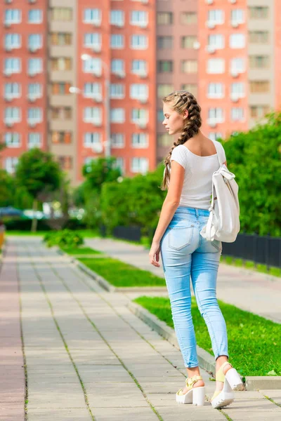 若い女の子はバックパック、バックで街歩き — ストック写真