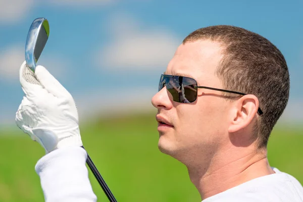 Close-up portrait of a golfer looking at his golf club — Stock Photo, Image