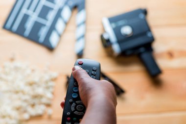 Film nesneleri arka plan üzerinde elinde TV'den uzak