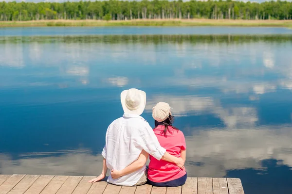 Молода щаслива пара обіймає і насолоджується відпочинком біля красивого озера — стокове фото